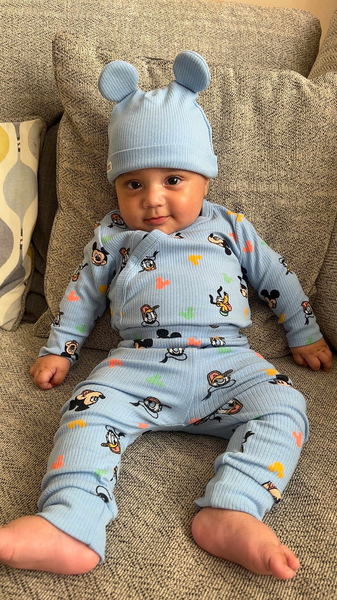 Kaiyan joined the competition — help win amazing prizes! baby, child, infant, blue_clothing, hat, ears, cartoon_characters, couch, textured_fabric, smiling, cute, indoors, comfortable, seated, foot, hand, face, portrait, cozy, playful