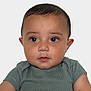 baby, child, portrait, face, eyes, hair, skin, expression, green_shirt, ribbed_clothing, cute, infant, young_child, front_view, studio_lighting, innocent, serious_expression, isolated_background, head_and_shoulders, toddler