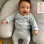 Hédi a rejoint le concours — aidez-le/la à gagner de superbes lots ! baby, smiling, infant, knitwear, cushion, polka_dot, milestone_card, indoor, happy, sitting, face, person, cozy, couch, cute, child, clothing, portrait, home, celebration
