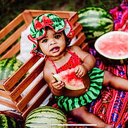 Rhemi joined the competition — help win amazing prizes! baby, blanket, child, crate, cute, food, fruit, grass, green, hat, nature, outdoor, playful, portrait, red, sitting, snack, summer, toddler, watermelon