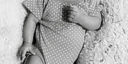 Jayla is registered to the contest to win money with this photo: baby, infant, polka_dot, onesie, headband, flower, blanket, fluffy, soft, portrait, black_and_white, cute, child, laying_down, relaxed, indoors, small_person, happy, skin, face