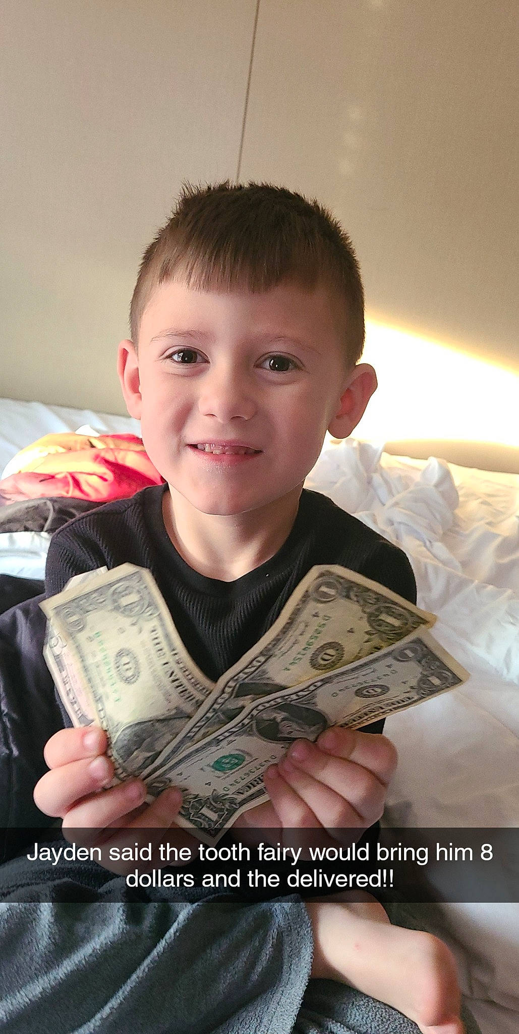 Jayden is registered to the contest to win money with this photo: banknote, blurred, cash, child, currency, dollar, finger, happy, joy, money, money_handling, paper, paper_product, person, publication, reading, recreation, room, saving, sitting