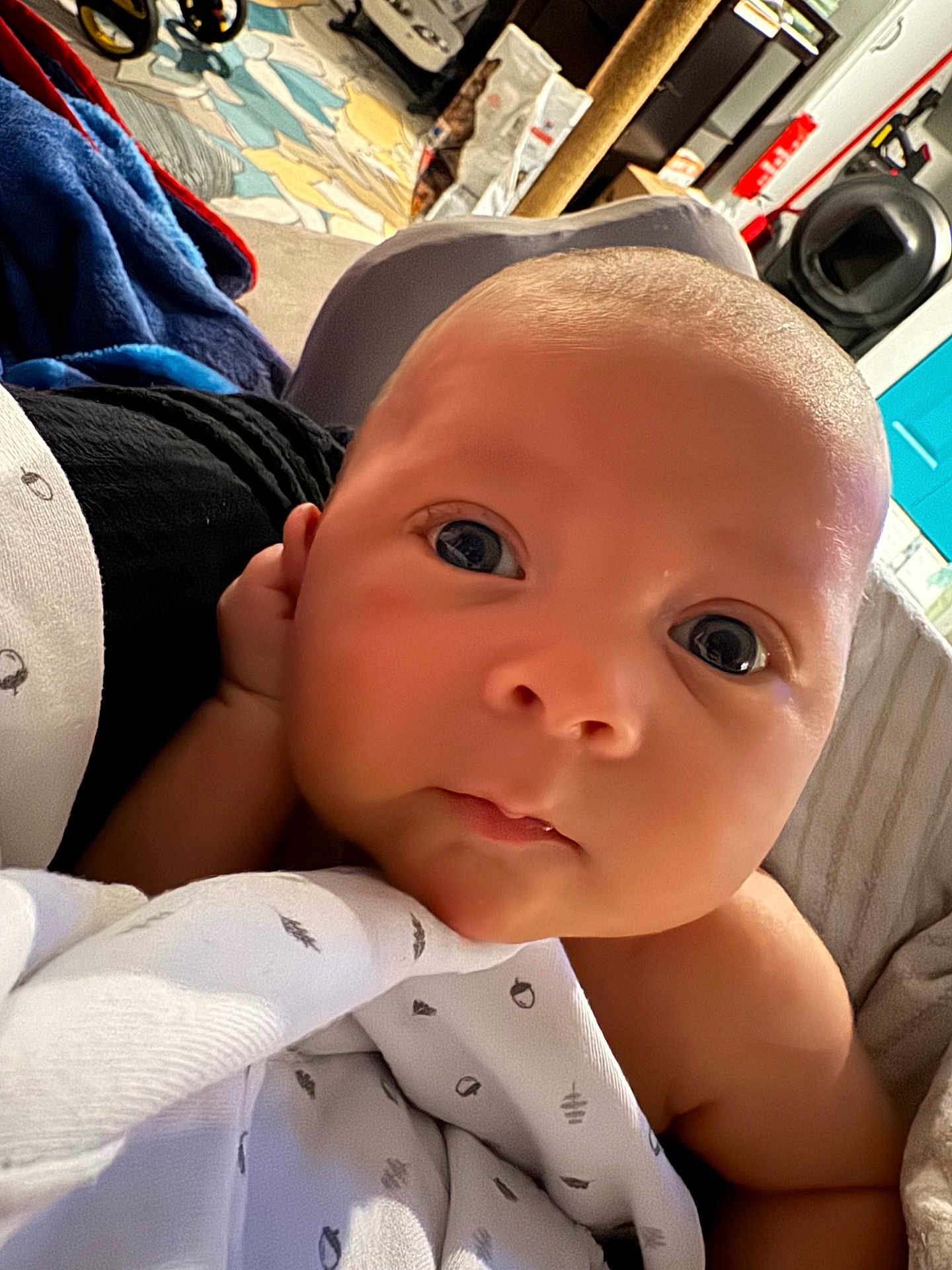 Eric joined the competition — help win amazing prizes! baby, newborn, infant, closeup, face, big_eyes, blanket, swaddle, hand, cheek, head, skin, mouth, nose, portrait, bedding, indoor, blanket_pattern, toy, helmet