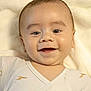 baby, smiling, infant, face, onesie, blanket, cute, child, portrait, happy, closeup, lying_down, skin, head, eyes, mouth, cheeks, young, clothing, soft