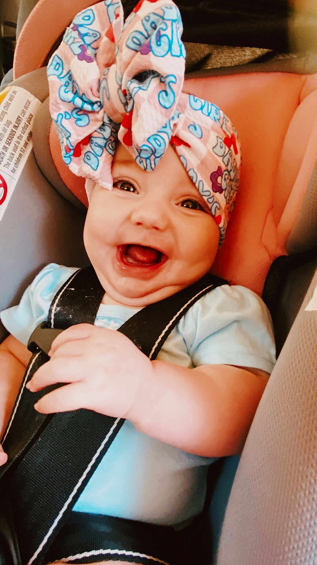 Blakelee is registered to the contest to win money with this photo: baby, smiling, car_seat, headwrap, child, infant, safety_harness, happy, cute, apparel, portrait, seat, straps, person, closeup, indoors, skin, hand, face, young_child