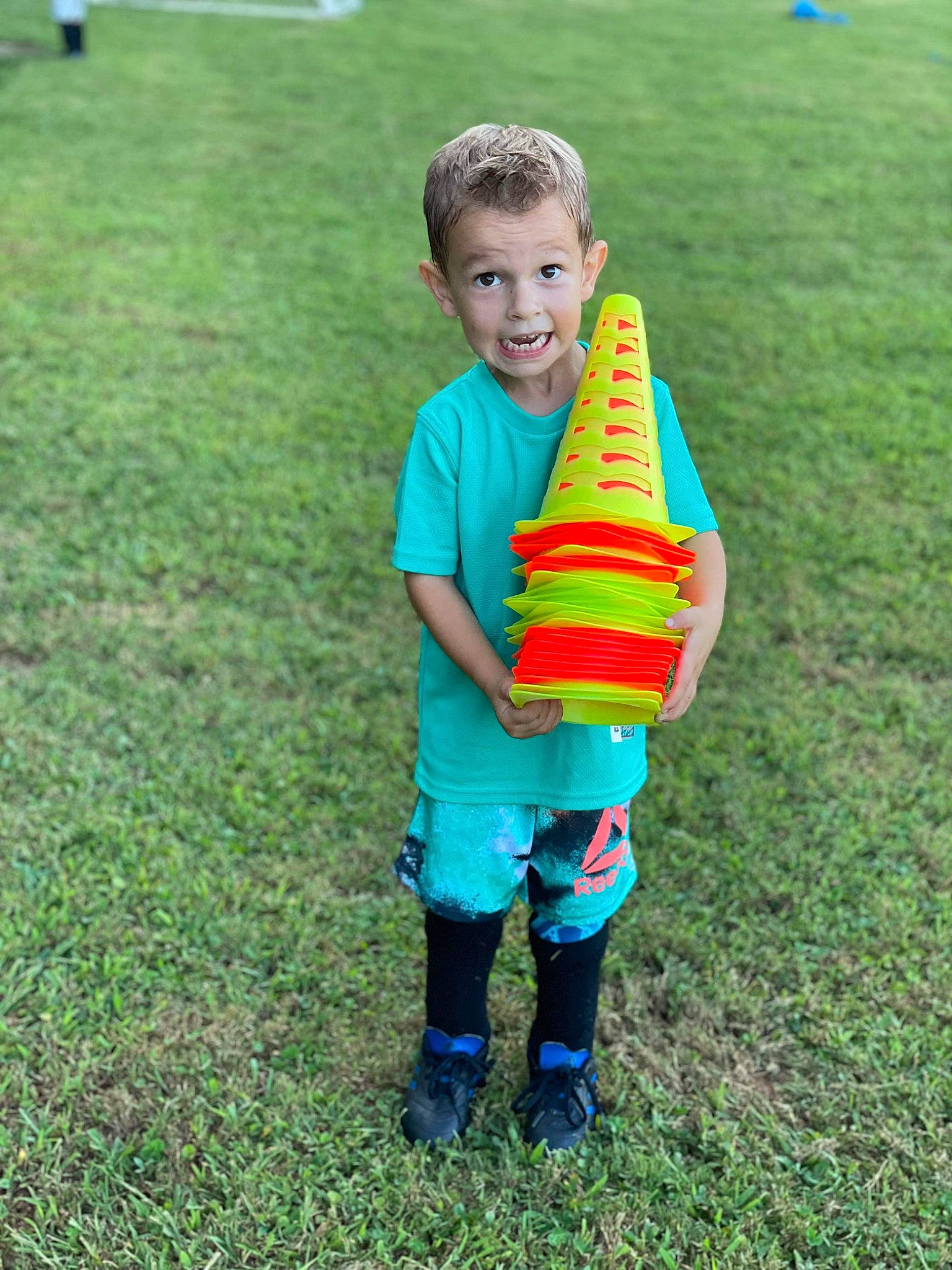 Jake is registered to the contest to win money with this photo: child, competition_event, electric_blue, fun, games, grass, grass_family, grassland, happy, lawn, leisure, people_in_nature, person, personal_protective_equipment, player, recreation, shorts, smile, surprise, t_shirt