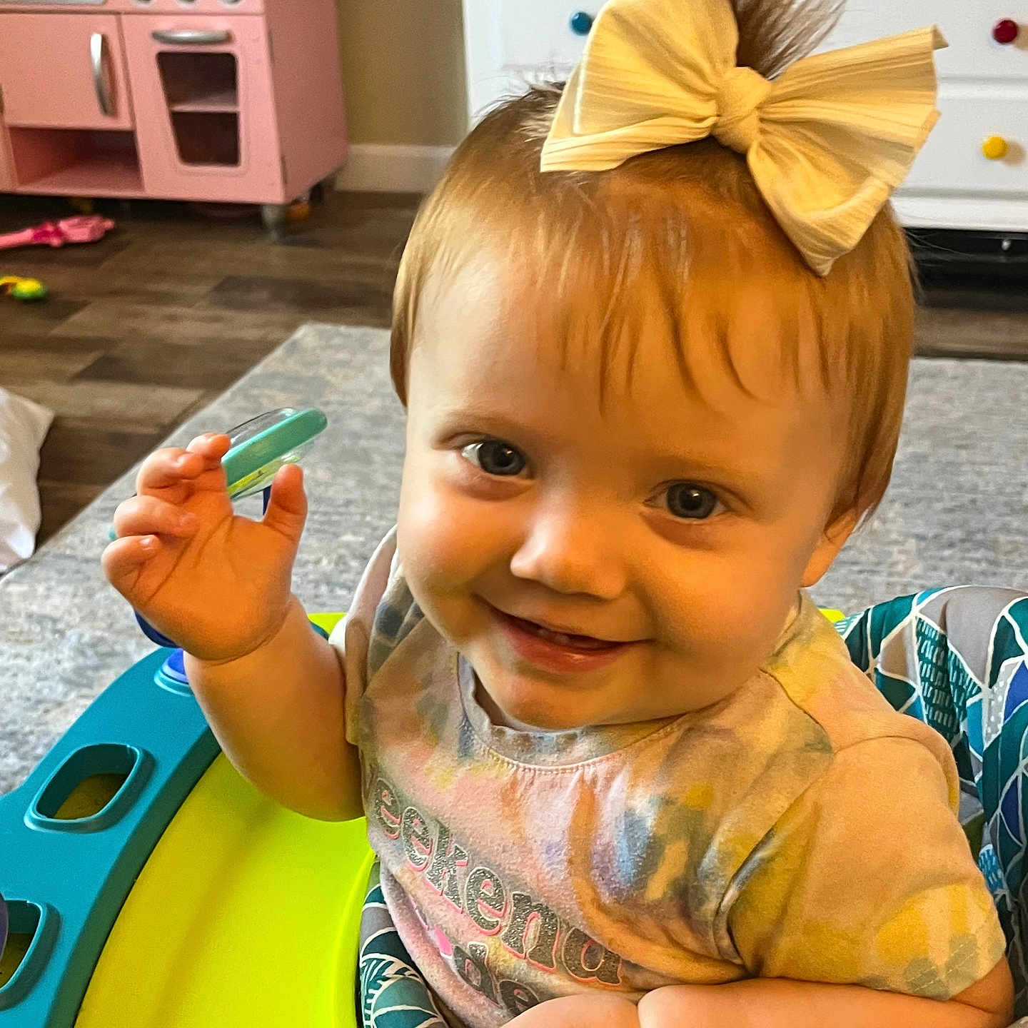 Mary is registered to the contest to win money with this photo: baby, baby_walker, bow, cabinet, carpet, child, clothing, cute, expression, face, floor, furniture, girl, hand, happy, indoor, pink, playroom, smiling, toy