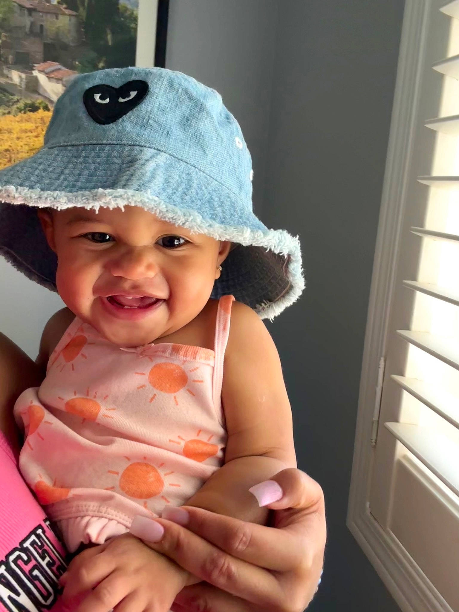 Aura is registered to the contest to win money with this photo: baby, baby_toddler_clothing, baseball_cap, cap, cheek, child, door, fashion_accessory, finger, fun, gesture, hand, happy, hat, headwear, lip, person, skin, smile, sun_hat