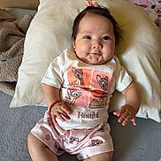 Alahia is registered to the contest to win money with this photo: baby, infant, child, pillow, blanket, bed, crib, smile, cute, clothing, socks, bracelet, hair_accessory, indoors, person, sitting, cute_outfit, bambi, soft_toys, happy