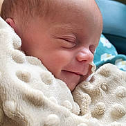 Emy participe au concours pour gagner de l'argent avec cette photo : baby, blanket, child, closeup, comfort, cozy, cute, face, head, indoors, infant, newborn, peaceful, portrait, resting, skin, sleeping, smiling, soft_texture, wrapped