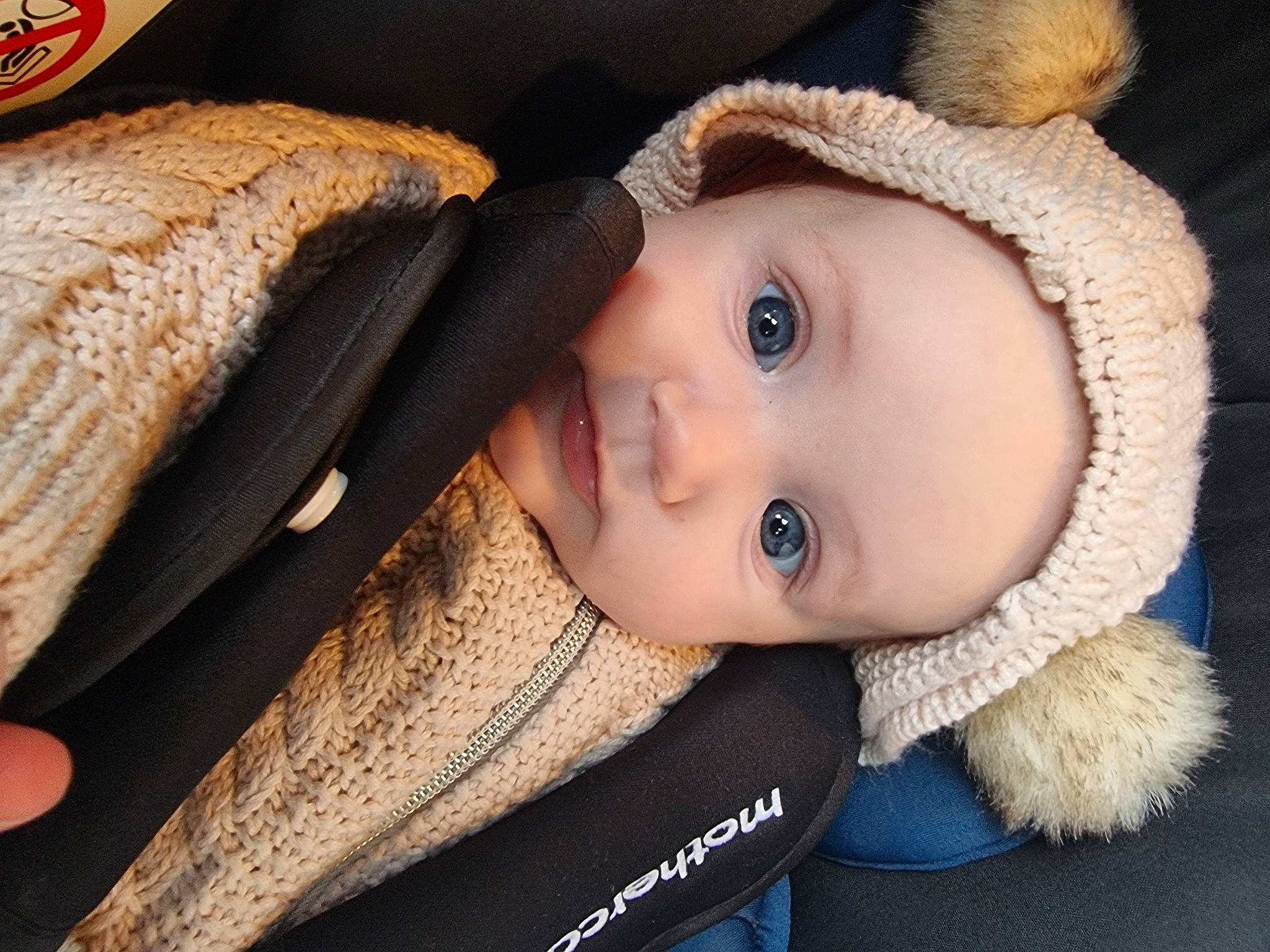 Imogen is registered to the contest to win money with this photo: baby, cap, cheek, child, eye, eyebrow, eyelash, face, headgear, headwear, iris, lip, mammal, nose, outerwear, person, skin, textile, toddler, vertebrate