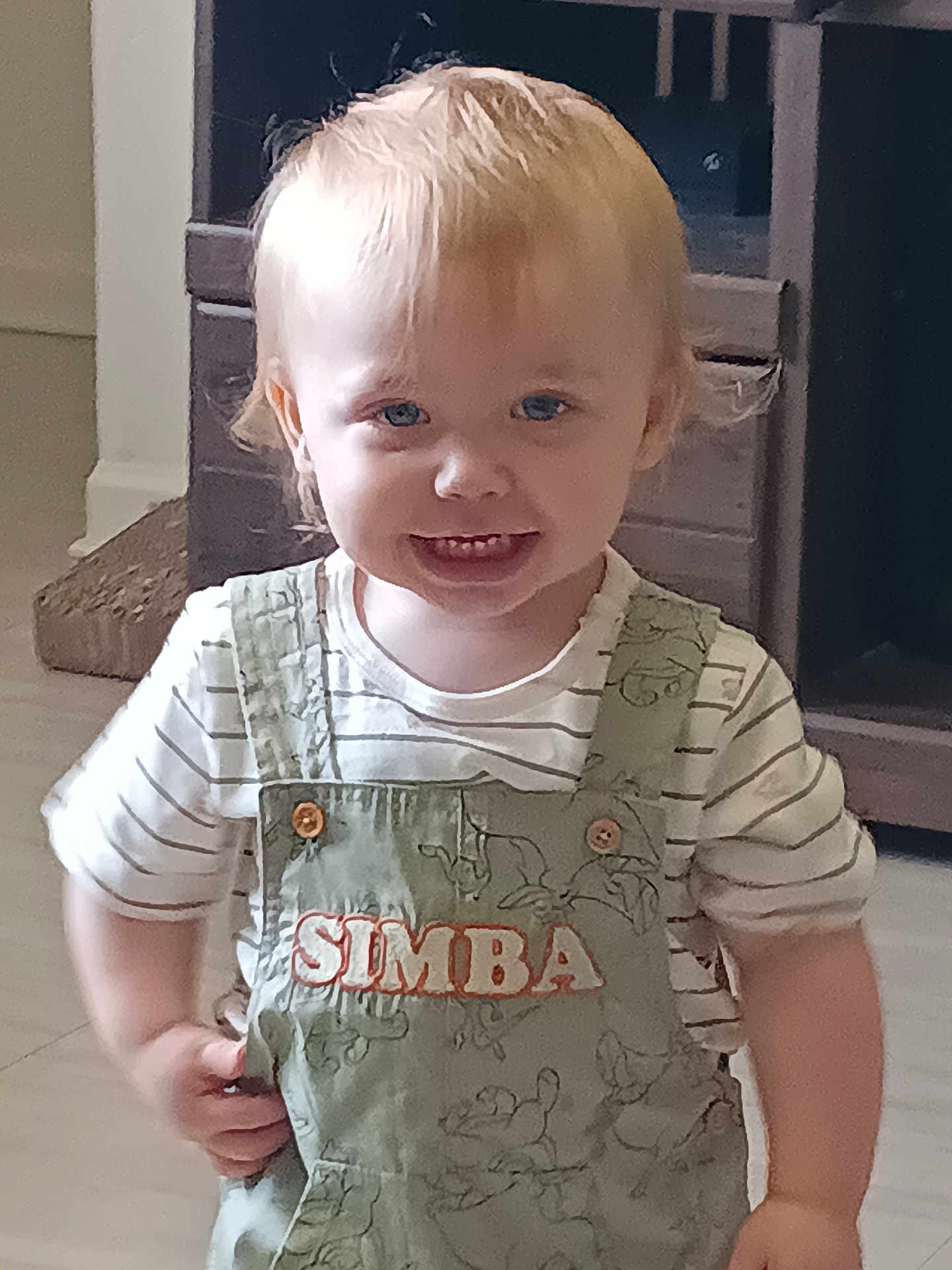 Roxas is registered to the contest to win money with this photo: toddler, child, smiling, indoor, overalls, light_hair, blue_eyes, striped_shirt, furniture, cabinet, wooden, floor, cute, happy, person, portrait, clothing, baby, standing, young_child