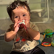Emilio joined the competition — help win amazing prizes! toddler, child, toy, chewing, curly_hair, sunlight, indoor, floor, play, cute, smiling, casual_clothing, shorts, tshirt, colorful_toys, baby, happy, person, portrait, young_child