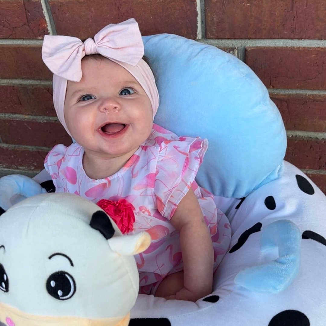 Ivy May joined the competition — help win amazing prizes! baby, blue_cushion, brick_wall, child, cushion, cute, dress, face, feet, happy, headband, infant, outdoor, person, pink_bow, plush_toy, polka_dots, portrait, seat, smiling