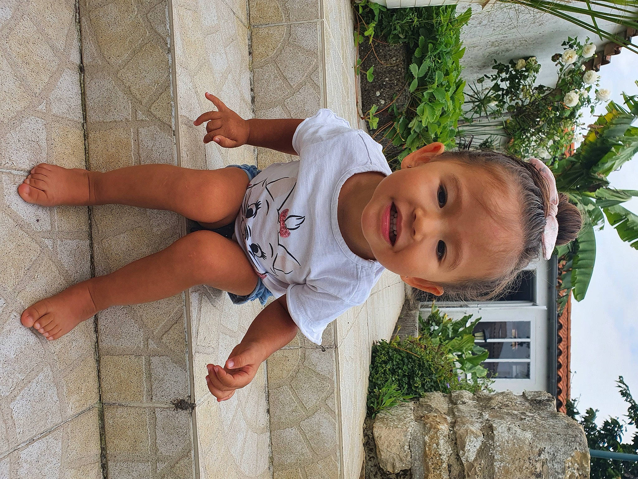 Arya participe au concours pour gagner de l'argent avec cette photo : baby_toddler_clothing, child, elbow, foot, fun, grass, happy, hat, house, human_body, human_leg, joint, leg, leisure, person, plant, shorts, sky, thigh, toddler