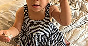 Egypt joined the competition — help win amazing prizes! child, toddler, girl, portrait, smiling, curly_hair, hair_bow, dress, patterned_clothing, sitting, bed, bedroom, indoors, face, eyes, hand_gesture, kneeling, bedding, home, photography