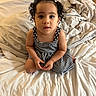 baby, child, toddler, portrait, curly_hair, sitting, bed, bedroom, blanket, bedding, dress, striped_dress, black_and_white, indoors, face, eyes, looking_at_camera, cute, photography, home