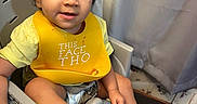 Egypt joined the competition — help win amazing prizes! baby, barefoot, child, crumbs, curly_hair, curtains, eating, face, food, happy, high_chair, home, indoor, photography, portrait, seated, smiling, toddler, wooden_floor, yellow_bib