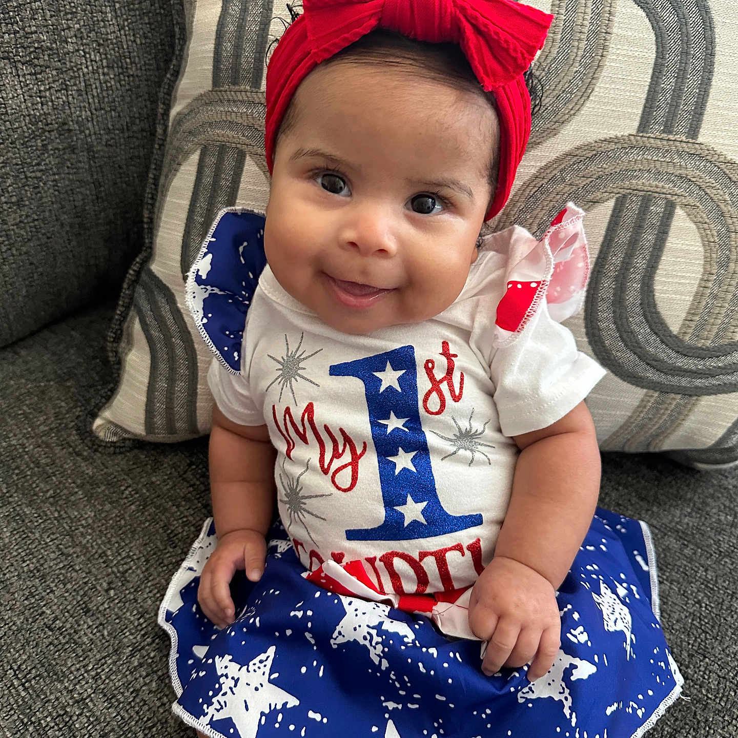 Mila is registered to the contest to win money with this photo: baby, clothing, costume, couch, cushion, dress, face, furniture, happy, head, homedecor, pants, person, photography, portrait, shorts, sitting, skirt, smile, t_shirt