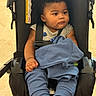 baby, child, stroller, curly_hair, blue_clothing, sweater, straps, infant, cute, seated, indoor, portrait, chubby_cheeks, looking_away, soft_lighting, casual, comfortable, young, person, baby_clothes
