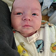 Noah joined the competition — help win amazing prizes! baby, infant, face, onesie, clothing, cartoon, yellow, blue, animal_print, person, close_up, indoor, cute, newborn, child, soft, warm, sleepwear, expression, holding