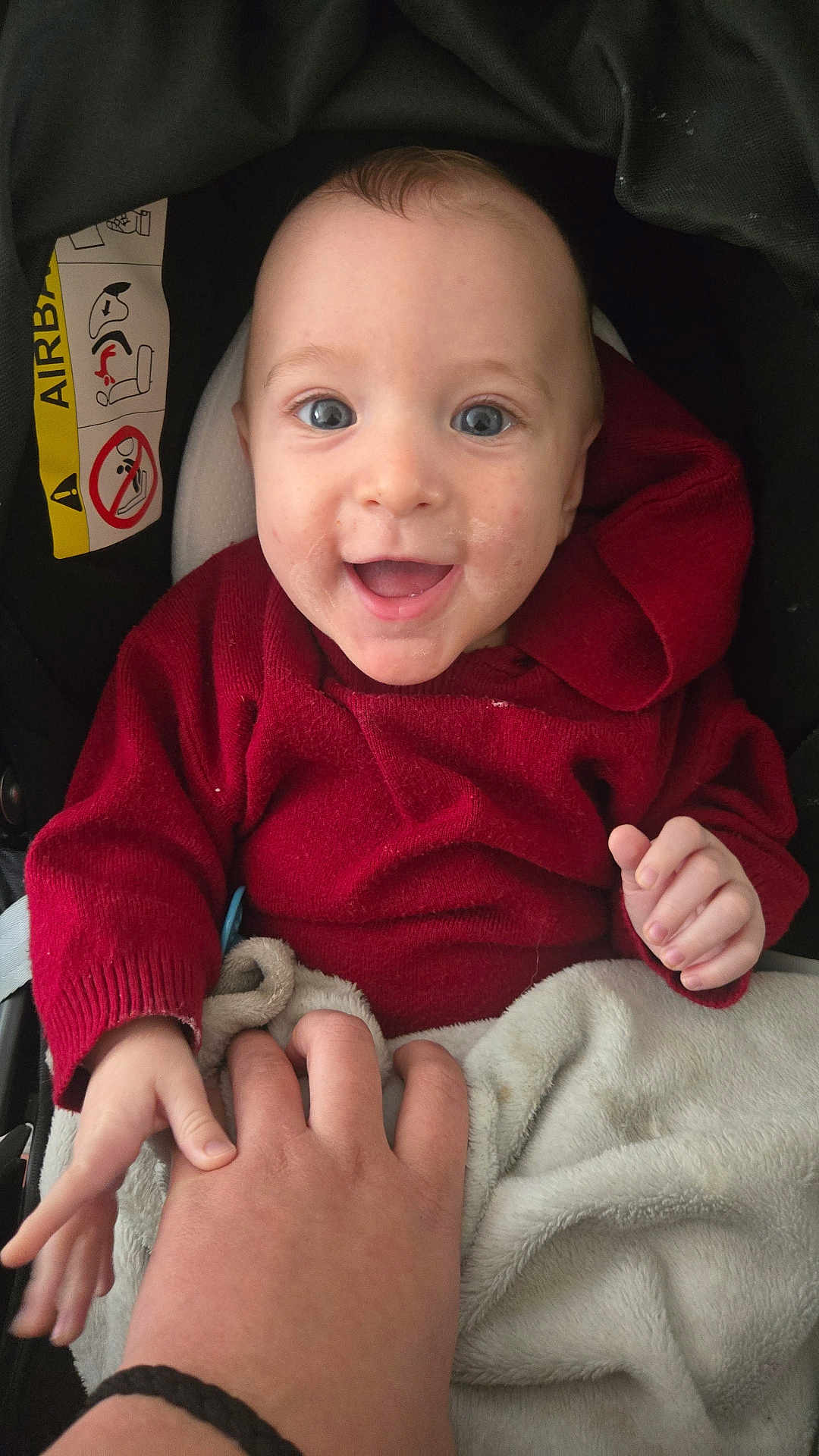 Charly participe au concours pour gagner de l'argent avec cette photo : baby, child, smile, happy, hand, red_sweater, blanket, car_seat, face, person, infant, clothing, cute, grip, interaction, warm, indoor, closeup, skin, expression