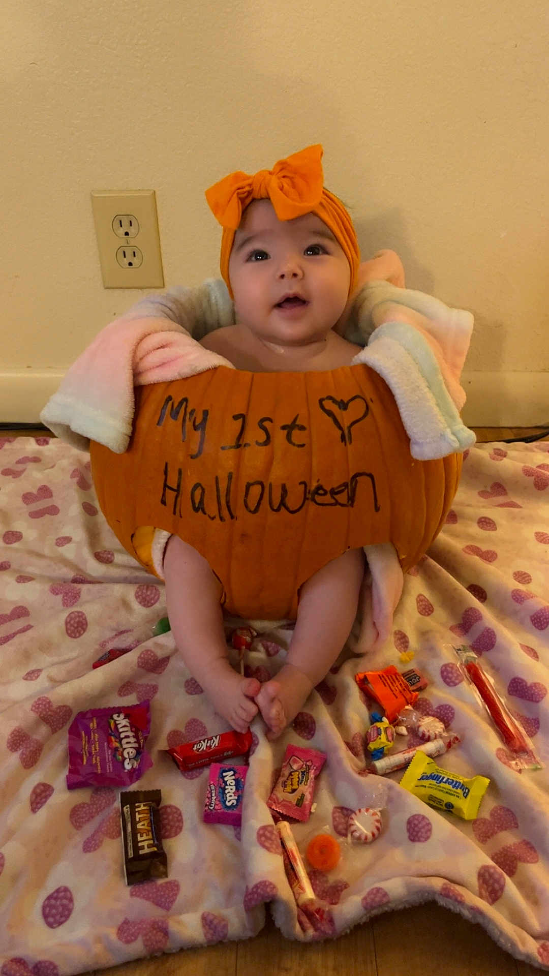Laseya is registered to the contest to win money with this photo: baby, pumpkin, halloween, candy, blanket, headband, orange, costume, child, cute, indoor, floor, sweet, holiday, celebration, feet, sitting, face, smile, decor