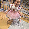 child, toddler, girl, smiling, portrait, pink_dress, tutu, bow, headband, fashion, indoors, mall, shopping_center, tiled_floor, railing, standing, shoes, shadow, playful, photography