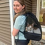 Taco joined the competition — help win amazing prizes! woman, smile, cat, pet_carrier, backpack, porch, house_siding, mesh, paw, orange_tabby, door, welcome_mat, shorts, tshirt, outdoor, reflection, earring, nose_ring, concrete_step, rock_border