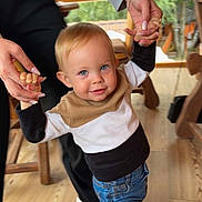 Elias a rejoint le concours — aidez-le/la à gagner de superbes lots ! child, toddler, blue_eyes, smiling, holding_hands, adult_hands, indoor, wooden_floor, jeans, sneakers, sweater, natural_light, window, furniture, casual_clothing, person, happy, playful, family, home