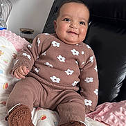 Aiyla joined the competition — help win amazing prizes! baby, child, smiling, cute, indoors, knitwear, brown_clothing, flower_pattern, sitting, blanket, soft_toy, cozy, happy, portrait, infant, furniture, face, head, warm, comfort