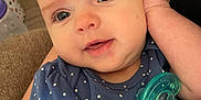 Anya joined the competition — help win amazing prizes! baby, infant, child, face, eyes, smile, blue_shirt, polka_dots, pacifier, hand, arm, person, indoors, cozy, comfort, close_up, skin, cute, young, portrait