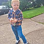 Kellen joined the competition — help win amazing prizes! child, boy, plaid_shirt, jeans, sneakers, snack, sidewalk, driveway, grass, tree, car, outdoor, daytime, casual, serious_expression, standing, person, nature, clothing, footwear