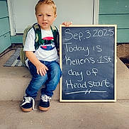 Kellen joined the competition — help win amazing prizes! child, boy, backpack, chalkboard, porch, door, jeans, sneakers, tshirt, hair, spike_hairstyle, writing, announcement, step, outdoor, casual_clothing, smile, american_flag, heart_emoji, milestone