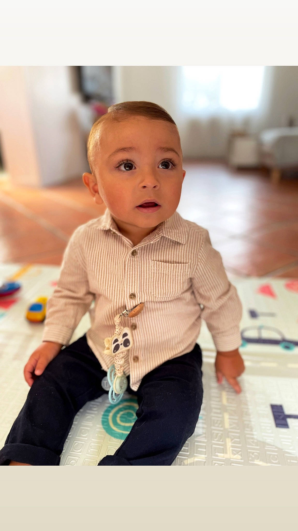 Tiago participe au concours pour gagner de l'argent avec cette photo : baby, baby_toddler_clothing, cheek, child, flooring, fun, happy, iris, pattern, person, play, portrait_photography, room, sitting, skin, sleeve, surprise, toddler, wood