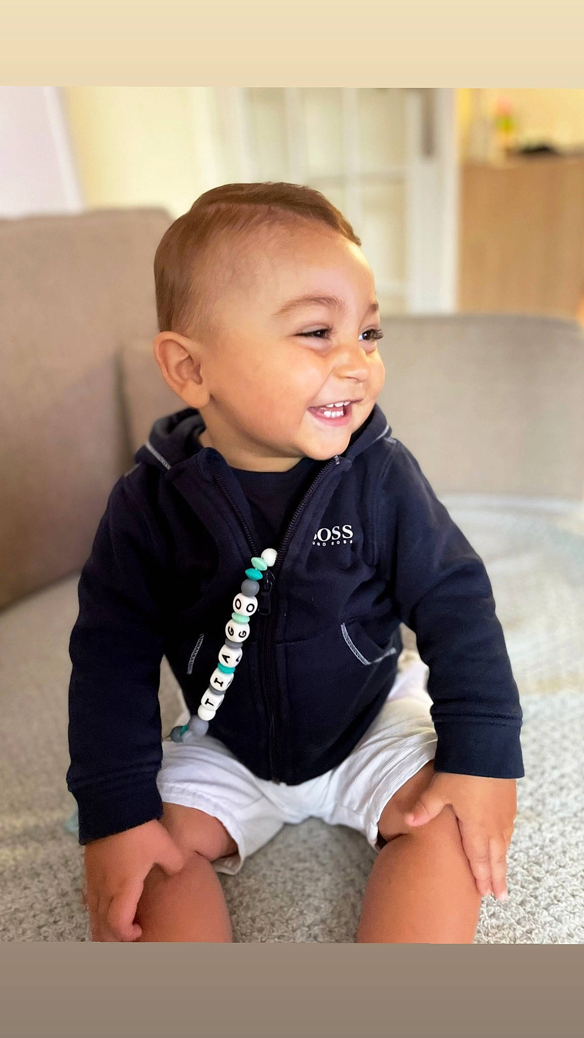 Tiago a rejoint le concours — aidez-le/la à gagner de superbes lots ! baby, baby_toddler_clothing, cheek, chin, clothing, comfort, flooring, happy, head, human_body, iris, joint, knee, neck, outerwear, person, skin, sleeve, smile, thigh