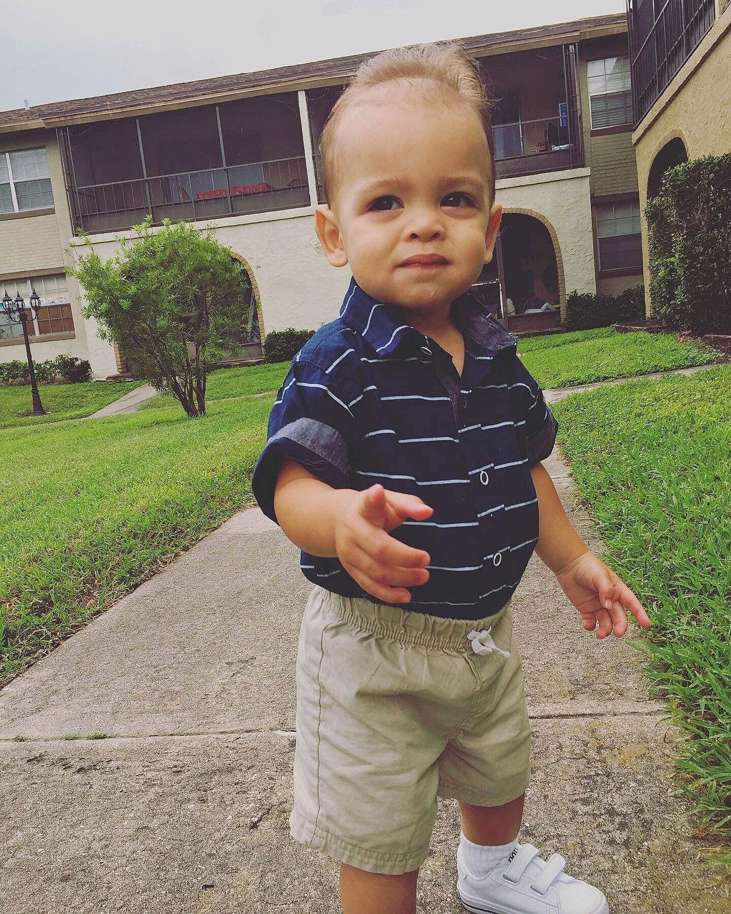 Alessandro is registered to the contest to win money with this photo: baby, child, cool, eye, face, grass, head, home, house, male, people, person, plant, shoe, shoulder, smile, standing, summer, t_shirt, toddler