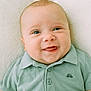 baby, infant, smile, face, child, polo_shirt, green_clothing, drool, cute, close_up, portrait, lying_down, soft_background, happy, young_child, eyes, skin, head, collar, buttoned_shirt