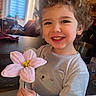 Erwan participe au concours pour gagner de l'argent avec cette photo : child, toddler, smile, curly_hair, flower, indoor, table, window, light, clothing, person, happy, face, toy, home, cute, portrait, holding, plant, cozy