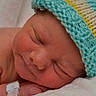 newborn, baby, sleeping, hat, knitted_hat, infant, closeup, face, peaceful, resting, blanket, skin, child, cute, soft, hospital_bracelet, portrait, young, cozy, indoors