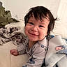 Lily Emelia is registered to the contest to win money with this photo: baby, smiling, indoor, blanket, bed, child, happy, portrait, toddler, clothing, face, hair, cute, lying_down, cozy, soft, person, infant, expression, young