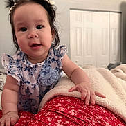 Lily Emelia joined the competition — help win amazing prizes! baby, child, infant, girl, pigtails, hair, blue_dress, flower_pattern, hand, blanket, bedroom, door, red_skirt, fabric, indoor, person, cute, portrait, smiling, skin
