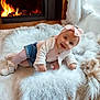 baby, child, infant, pink_bow, headband, knitted_vest, white_rug, fireplace, wood_floor, smiling, cute, indoor, cozy, warm_lighting, shorts, white_shoes, pacifier, happy, portrait, candid