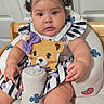 baby, baby_feet, chair, child, colorful, cup, dress, face, hair_bows, high_chair, home, indoor, infant, portrait, purple_bows, sitting, smiling, striped_clothing, teddy_bear, toy