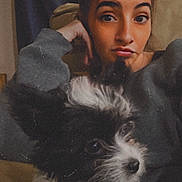 Mooka is registered to the contest to win money with this photo: person, dog, indoor, selfie, digital_filter, devil_horns, fluffy_dog, black_and_white, casual, couch, sweater, pet, companion, relaxed, portrait, cute, animal, fun, home, curious