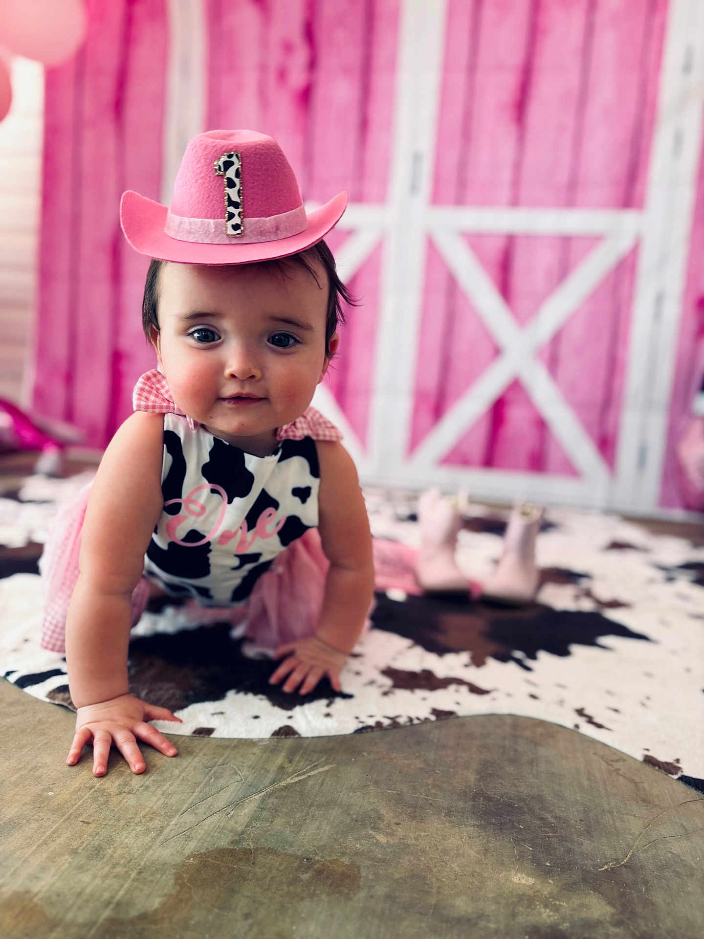 Emma Jean joined the competition — help win amazing prizes! baby, girl, crawling, cow_print, pink_hat, birthday, cowhide_rug, pink_tutu, boots, indoor, child, cute, portrait, floor, rustic, barn_door, hat, number_one, celebration, smiling