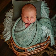 Rook joined the competition — help win amazing prizes! newborn, baby, sleeping, blanket, basket, cozy, soft, wrapped, peaceful, infant, cute, resting, indoors, texture, wooden_floor, pillow, homedecor, portrait, baby_bedding, warm