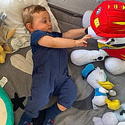 Manuel participe au concours pour gagner de l'argent avec cette photo : baby, blanket, blue_overalls, child, comfortable, cushion, cute, floor, indoor, infant, mesh, pillow, playpen, plush_toy, reaching, socks, soft_toys, stuffed_animal, toddler, toy