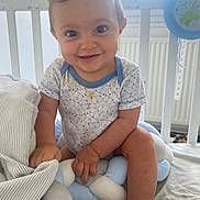Manuel a rejoint le concours — aidez-le/la à gagner de superbes lots ! baby, child, smiling, crib, cushion, onesie, blue, white, indoor, person, cute, infant, happy, soft, plush, clothing, furniture, hand, face, young