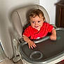 baby, child, cute, domestic, face, furniture, hand, happy, high_chair, home, indoor, person, playful, red_clothing, seat, smiling, toddler, tray_table, wooden_floor, young_child
